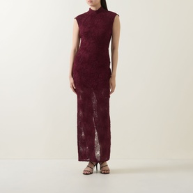 Model wearing Rotate Decadent Chocolate lace maxi dress with mock neck, cap sleeves, and front split, styled with strappy heeled sandals.