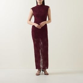 Model wearing Rotate Decadent Chocolate lace maxi dress with mock neck, cap sleeves, and front split, styled with strappy heeled sandals