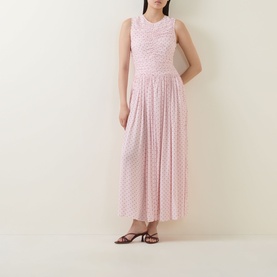 Model wearing Rotate barely pink sleeveless midi dress with pleated skirt and floral texture, styled with black strappy heeled sandals.