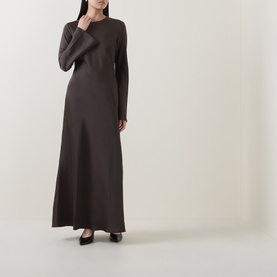 Model wearing Rotate Black Olive long sleeve maxi dress in smooth fabric with crew neck and flared skirt, styled with black heels