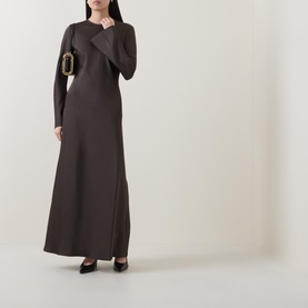 Model wearing Rotate Black Olive maxi dress with long sleeves and crew neck, styled with black heels and a gold-hardware box bag.