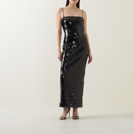 Model wearing Rotate black sequin maxi dress with thin straps and fitted silhouette, styled with black strappy heels