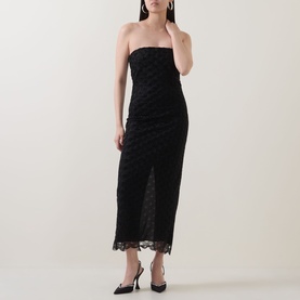 Model wearing Rotate black strapless midi dress with textured lace overlay and scalloped hem, styled with black heels and drop earrings.