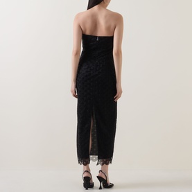 Model wearing Rotate black strapless midi dress with polka dot burnout fabric and lace hem trim, rear view