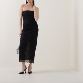 Model wearing Rotate black strapless lace midi dress with front split, styled with black heels and a small silver clutch bag