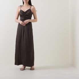 Model wearing Rotate Black Olive maxi dress with ruched bust, double straps, and flowing silhouette, styled with strappy heeled sandals.