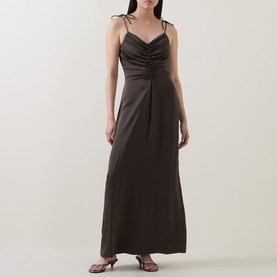 Model wearing Rotate Black Olive maxi dress with ruched bodice, tie shoulder straps and A-line skirt, styled with strappy heeled sandals.