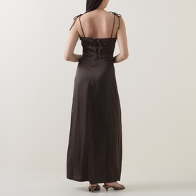 Model wearing Rotate Black Olive maxi dress, back view, satin finish with double shoulder straps and tie detail, open back