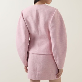 Model wearing Rotate Cherry Blossom jacket, rear view, styled with matching mini skirt in the same pink hue.