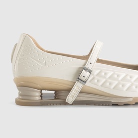 Cream patent leather Mary Jane flat with silver buckle strap, embossed geometric upper, and sculpted beige rubber sole, close-up detail view
