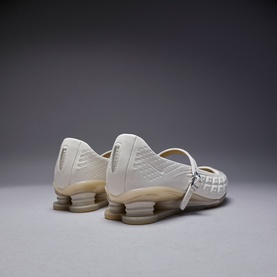 Cream white trainers with quilted upper, mary jane strap, and translucent spring heel units, rear view
