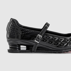 Nike Shox Z Calistra Ballet Flats in black patent synthetic leather with buckle ankle strap and Shox Z cushioned sole, close-up side view.