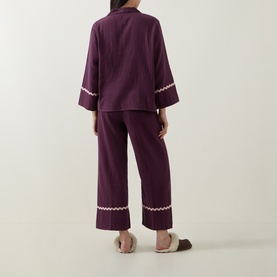 Model wearing Their Nibs Fig Baby Wavy-Trim Pyjama Set in fig, showing back view with wavy trim at cuffs and cropped hems