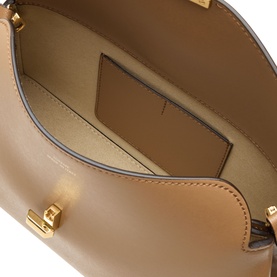 Toteme T-Lock Leather Clutch in camel, interior view showing card slot, zip pocket, and smooth leather lining with gold-tone hardware detail.