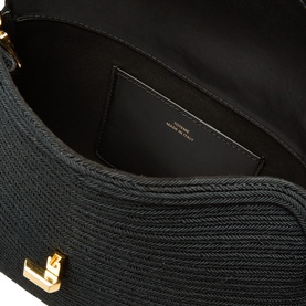 Toteme T-Lock Rope Clutch in black, interior view showing card slot and gold-tone T-lock hardware detail on flap closure.