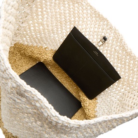 Toteme ecru/vanilla woven paper tote bag, interior view showing black leather pouch insert with gold-tone clasp