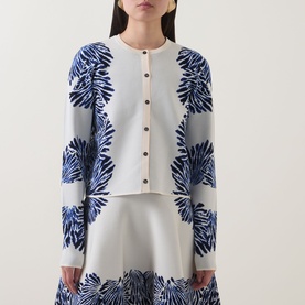 Model wearing Ulla Johnson Carina Jacquard Cardigan in Lapis, white knit with blue botanical jacquard pattern, button front, styled with matching