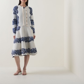Model wearing Ulla Johnson Carina Jacquard Cardigan in Lapis, with matching blue floral jacquard midi skirt and nude heels.