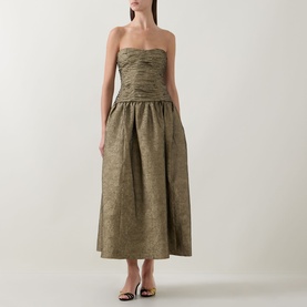Model wearing Ulla Johnson Lumina Textured Gown in Light Gold, strapless sweetheart neckline, ruched bustier, flared midi skirt, styled with strappy