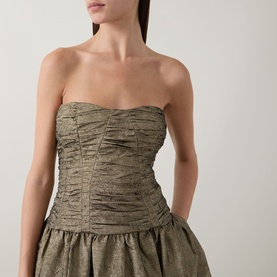 Model wearing Ulla Johnson Lumina Textured Gown in Light Gold, strapless sweetheart neckline with ruched fitted bustier and flared skirt in crinkle