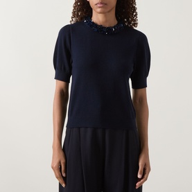 Model wearing Ulla Johnson Jude Embellished Top in Midnight, featuring embellished round neckline, short puff sleeves and fine knit structure.