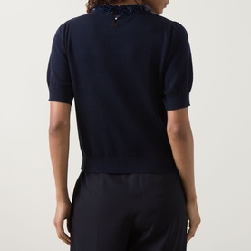 Model wearing Ulla Johnson Jude Embellished Top in Midnight, back view showing short sleeves, straight hemline and fine merino knit