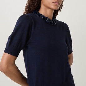 Model wearing Ulla Johnson Jude Embellished Top in Midnight, close-up of sequin-embellished round neckline and short puff sleeves