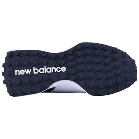 New Balance trainer sole detail showing navy rubber outsole with multi-directional lugs and white New Balance logo branding.