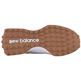 New Balance trainer sole view showing white outer edge and tan gum rubber outsole with textured grip pattern