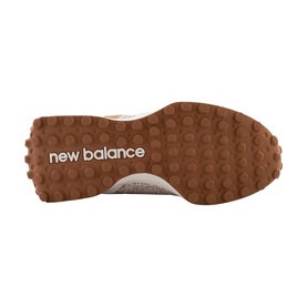 New Balance trainer sole view showing tan rubber outsole with textured tread pattern and embossed New Balance branding.