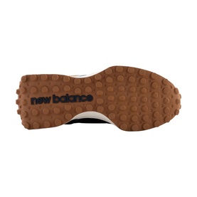 New Balance trainer sole detail showing gum rubber outsole with textured grip pattern and New Balance logo branding in black.