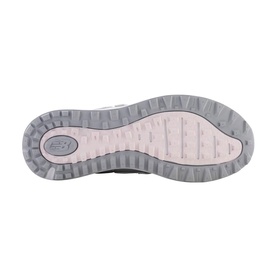 Grey and pink rubber outsole of a New Balance trainer, showing deep lug tread pattern and NB logo embossed at heel.