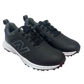 New Balance black leather golf shoes with white spiked sole, grey N logo detail, and blue accent stripe on heel counter