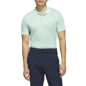 Model wearing Adidas Golf polo shirt in Clear Mint, short sleeves, styled with navy trousers and black belt