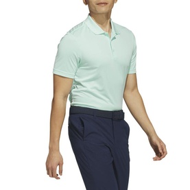 Model wearing Adidas Golf Clear Mint polo shirt with short sleeves, styled with navy trousers