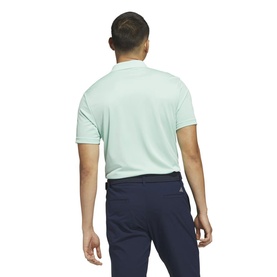 Model wearing Adidas Golf shirt in Clear Mint, rear view, styled with navy trousers.