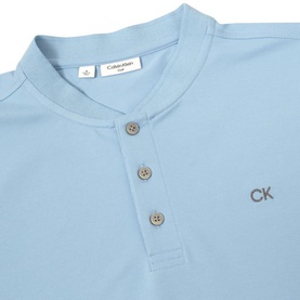 Calvin Klein Golf Sky Blue polo shirt, close-up showing Henley neckline with three buttons and embroidered CK logo chest detail.