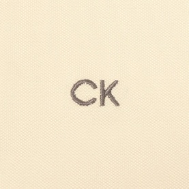 Close-up of embroidered CK logo in grey on cream textured fabric