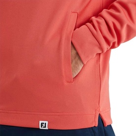 Model wearing Footjoy hoodie in Solid Nantucket Red, close-up of kangaroo pocket and FJ logo badge at hem.
