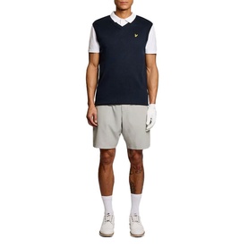 Model wearing navy knitted V-neck vest over white polo shirt, styled with grey shorts and white trainers