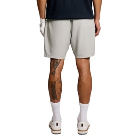 Model wearing light grey shorts, rear view, styled with a navy tee and white socks with cream trainers