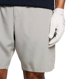 Model wearing light grey tailored shorts, styled with a white golf glove visible at hip pocket