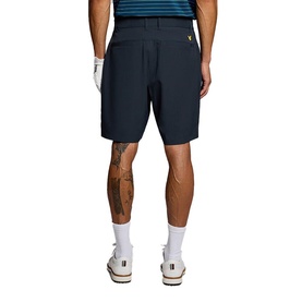 Model wearing Lyle & Scott Golf shorts in Dark Navy, back view, styled with white socks and trainers and a striped polo shirt.