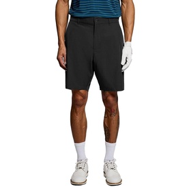 Model wearing Lyle & Scott Golf shorts in Jet Black, styled with a striped polo shirt, white socks and golf shoes.
