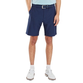 Model wearing Footjoy navy golf shorts with a white belt, styled with white golf shoes and a light blue polo shirt.