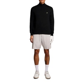 Model wearing Lyle & Scott Golf quarter-zip top in Jet Black, styled with grey shorts and white trainers.
