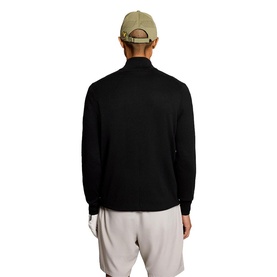 Model wearing Lyle & Scott Golf top in Jet Black, rear view, styled with a beige cap and light grey shorts.