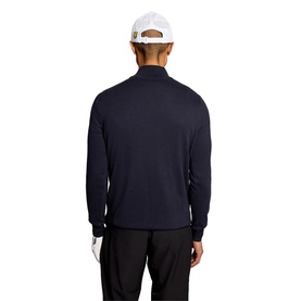 Model wearing Lyle & Scott Golf top in Dark Navy, rear view, styled with white cap and black trousers.