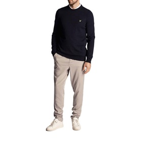 Model wearing Lyle & Scott Golf crew neck jumper in Dark Navy, styled with taupe trousers and white trainers