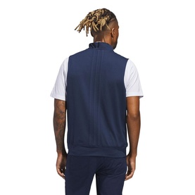 Model wearing Adidas Golf gilet in Collegiate Navy, rear view, styled with white polo shirt and navy trousers.